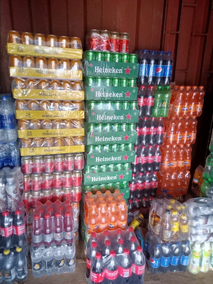 Un dépôt de boissons, casiers et packs de bouteilles empilés jusqu'au plafond