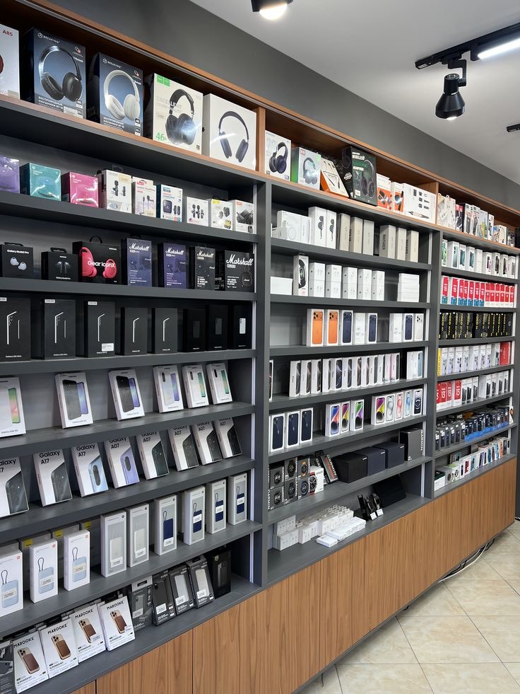 Un magasin de téléphones et d'électronique, rayonnages de smartphones, casques et accessoires en boîte